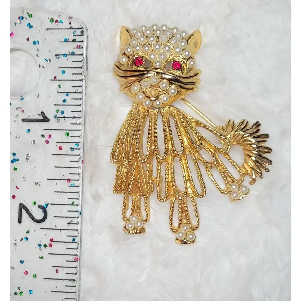 Vintage gold-tone cat brooch with red rhinestone eyes and white beaded accents